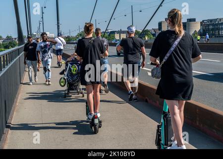 Fußgänger und E-Scooter auf einem Bürgersteig, sich gegenseitig in die Nähe kommen, illegales Fahren auf dem Bürgersteig durch E-Scooter-Nutzer, Düsseldorf, NRW, Stockfoto