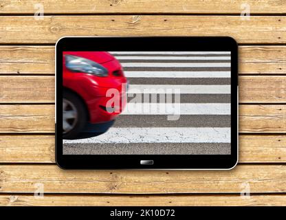 Schwarz-weiß Fußgängerüberweg mit rotem Auto auf dem Hintergrund - Konzeptbild mit 3D Rendering eines digitalen Tablets - die Form des Autos wurde geändert Stockfoto