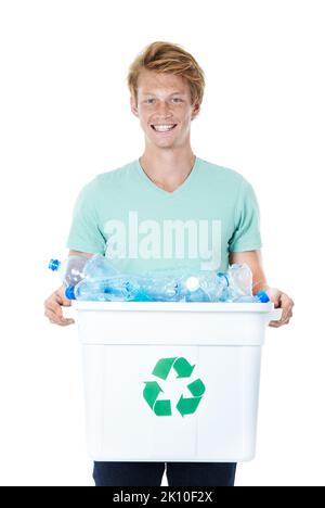 Wir alle können etwas bewirken. Ein glücklicher junger Mann mit rotem Kopf, der einen mit leeren Plastikflaschen gefüllten Recyclingbehälter in der Hand hält. Stockfoto