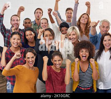 Gemeinsam erreichen alle mehr. Eine Gruppe von Kollegen stanzt in die Luft. Stockfoto