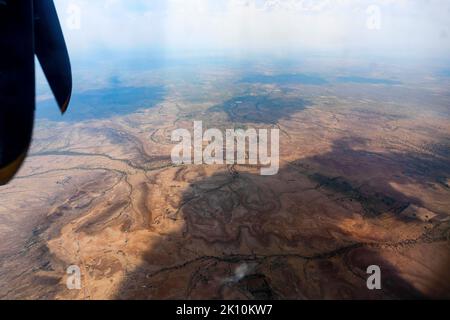 Blick auf die Thar-Wüste aus einem Flugzeug, Rajasthan, Indien. Die Propeller und Thar wüsten im Rahmen. Schönes Spiel von Sonnenlicht und Wolken Schatten auf Stockfoto