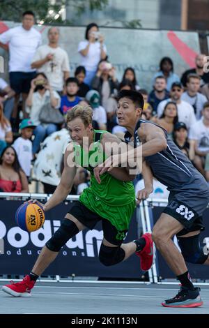 Montreal, Kanada, 03. September 2022: Canyon Barry (grün) vom Team Princeton aus den USA im Einsatz gegen Yuanbo Zhu (grau) vom Team China während der Poolrunde der 2022 FIBA 3x3 World Tour Montreal Masters auf dem Place des Festivals in Montreal, Kanada. Das Team Beijing of China gewann das Spiel mit 19:18 Punkten. Stockfoto