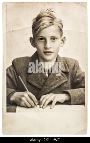 Altes Foto des Schuljungen. Vintage-Bild mit Original-Film-Körnung, Unschärfe und Kratzern Stockfoto