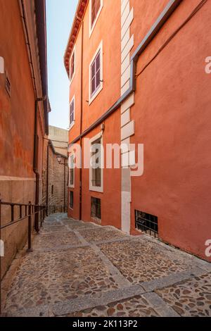 Enge Gassen der Altstadt von Toledo mit roten Wänden Stockfoto