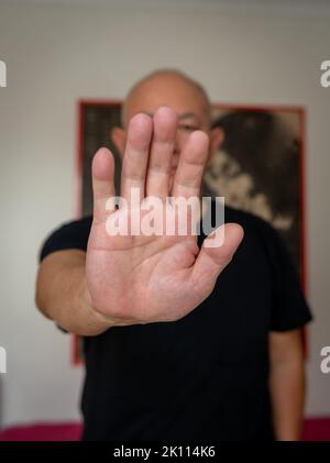 Ein älterer Mann, der in der Halle die Kampfkunst übt. Stockfoto