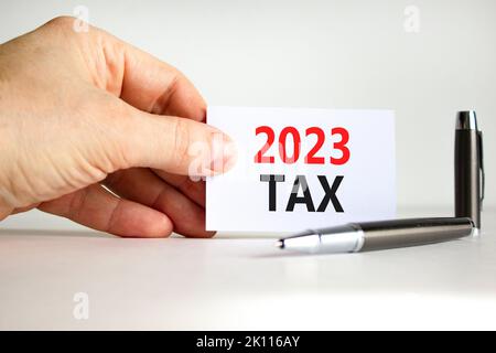 Symbol für 2023 Steuern für das neue Jahr. White Paper mit den Worten 2023 Steuer. Geschäftsmann Hand. Metallstift. Schöne weiße Tabelle weißen Hintergrund. Business und 2023 t Stockfoto