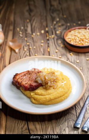 Tschechische Küche, geräuchertes Fleisch mit Erbsenbrei und gebratene Zwiebel bis golden Stockfoto