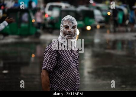 Dhaka, Bangladesch. 14. September 2022. Ein Mann, der während einer Regendusche seinen Kopf mit einer Plastiktüte bedeckt, während er nach Hause in Dhaka pendelt. Die Hauptstadt Dhaka verzeichnete in den letzten 24 Stunden unter dem Einfluss des Niederdrucks in der Bucht von Bengalen 53 mm Regen. Die Regenzeit in Bangladesch fällt mit der Sommermonsunsaison (Juni bis Mitte Oktober) zusammen, und die Niederschläge in dieser Saison machen 75-80% der jährlichen Niederschläge des Landes aus. (Bild: © Md. Rakibul Hasan/ZUMA Press Wire) Stockfoto