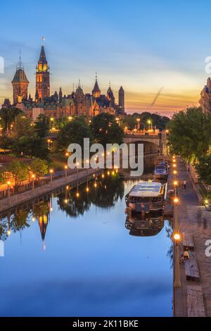 Blue-Hour-Blick auf Parliament Hill spiegelt sich im Rideau Canal in der Innenstadt von Ottawa, Ontario, Kanada, während die Lichter der Stadt die historische Hauptstadt erleuchten Stockfoto