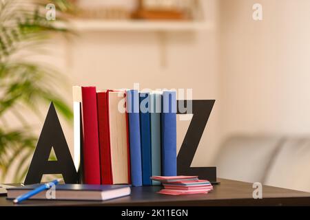 Stilvoller Halter mit Büchern auf dem Tisch im Zimmer Stockfoto