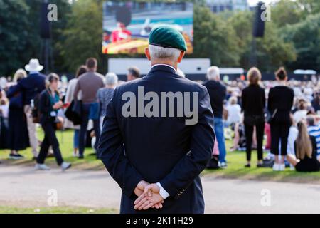 London, Großbritannien. 14. September 2022. Als Menschenmassen nach London kamen, um zu beobachten, wie der Sarg Ihrer Majestät der Königin zum Palast von Westminster transportiert wurde, wird ein ehemaliger Militärangehöriger auf großen Videoleinwänden im Hyde Park, London, abgebildet, wie er das Ereignis beobachtet. Quelle: Lynchpics/Alamy Live News Stockfoto