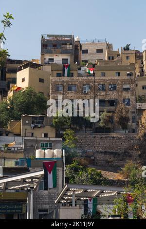 06.18.2022. Amman, Jordanien. Alte Gebäude und Häuser mit der Flagge Jordaniens auf ihnen. Hochwertige Fotos Stockfoto