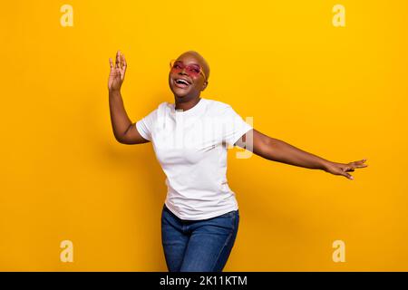 Foto von überglücklich Dame Frau Musik Liebhaber Tanz hat Chill heben Arme genießen Sommerparty Freizeit isoliert auf gelbem Hintergrund Stockfoto