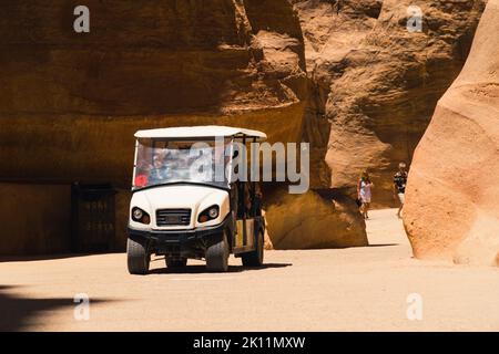 06.18.2022. Petra Canyon, Jordanien. Touristenauto, das durch die enge Passage der felsigen Berge fährt. Hochwertige Fotos Stockfoto