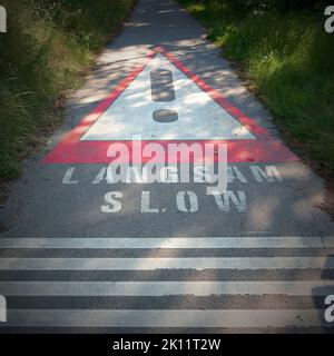 Bitte langsam auf einer schmalen Asphaltstraße in Österreich fahren Stockfoto