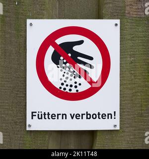 Schild mit der Aufschrift Fütterung am Zaun in einem Zoo in Deutschland verboten Stockfoto