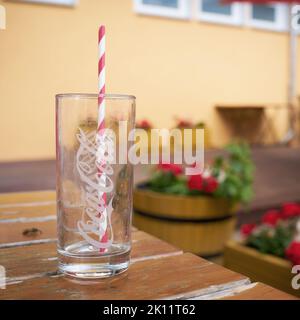 Leeres Coca-Cola-Glas mit Stroh auf dem Tisch im Restaurant Stockfoto