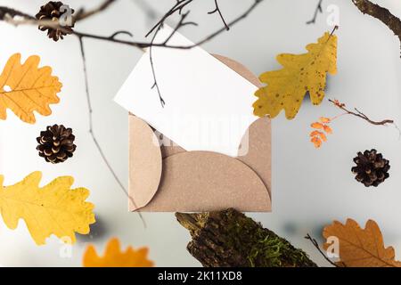 Herbstblätter auf einem trüben mehrstufigen Hintergrund, mit natürlichen Elementen, Treibholz und Ästen. Nachbau einer weißen Postkarte. Hochwertige Fotos Stockfoto