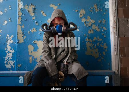 Post-Apokalypse weibliche Überlebende in Gasmaske. Umweltkatastrophe, Luftverschmutzung Stockfoto