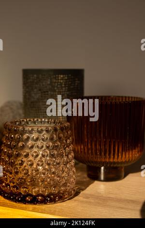 Kerze und aromatischer Reed-Freshener auf dem Tisch. Aroma Flüssigkeit in Glasflasche mit Schilfstöcken. Aromadiffusor. Hygge. Skandinavische Wohnkultur Kerzen, Duft Stockfoto