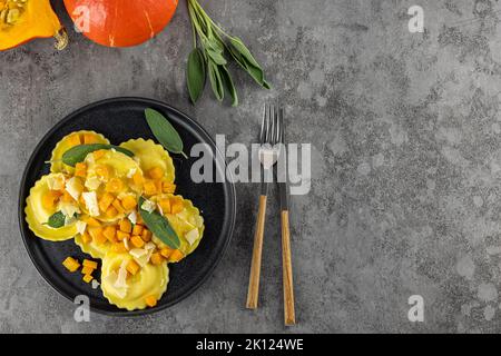 Saisonales Herbstrezept. Kürbisravioli mit Salbei, Parmesan und Olivenöl. Stockfoto