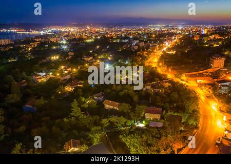 Luftaufnahme von der Drohne der beleuchteten Stadt in der Dämmerung. Varna, Bulgarien Stockfoto