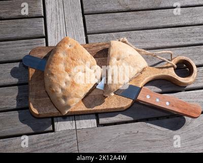 Brotbrett mit Brotmesser und zwei Stück türkisches Brot Stockfoto