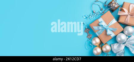 Festlicher Hintergrund mit Weihnachtskugeln, Geschenken und Dekorationen auf blauem Hintergrund. Stockfoto