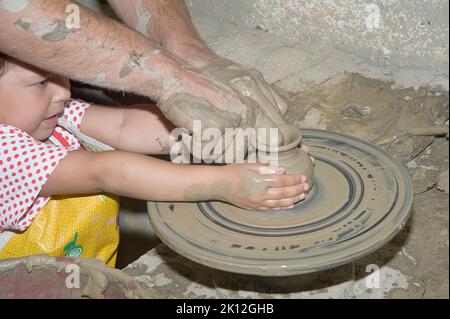 Potters Arbeit am alten Töpferrad Stockfoto