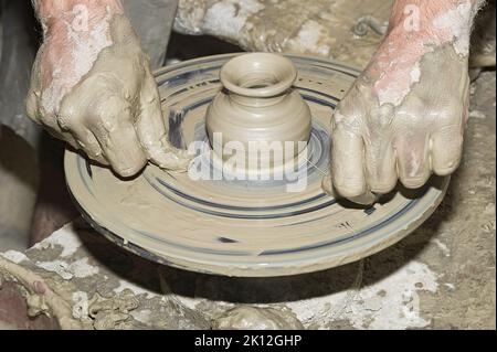 Potters Arbeit am alten Töpferrad Stockfoto