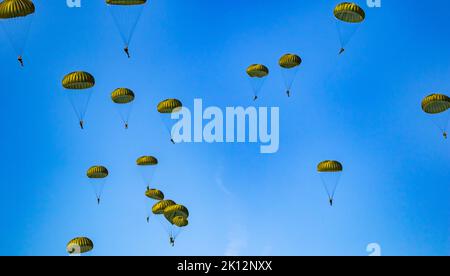 Militärparachutist Fallschirmjäger Fallschirm springen aus einer Luftwaffe Flugzeuge an einem klaren blauen Himmel Tag mit dem Mond. Stockfoto