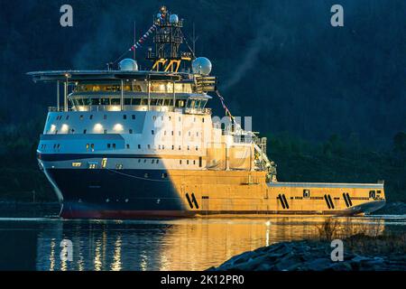 Offshore-Schiff Island Victory segelt auf ihrem ersten Trip mit ihren Flaggen oben Stockfoto