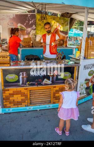 Manavgat, Türkei - 8. September 2022: Mann in türkischer Tracht verkauft traditionelles türkisches Eis in einer Straße von Manavgat, Türkei Stockfoto