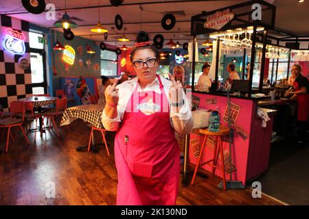 Ein miserabler Mitarbeiter gibt dem Fotografen den Finger an Karen’s Diner in Prestwich, Manchester. Karens ist nichts für schwache Nerven, aber es ist es Stockfoto