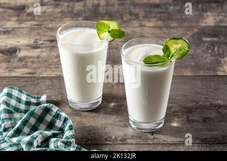 Ayran Drink mit Minze und Gurke im Glas auf Holztisch Stockfoto