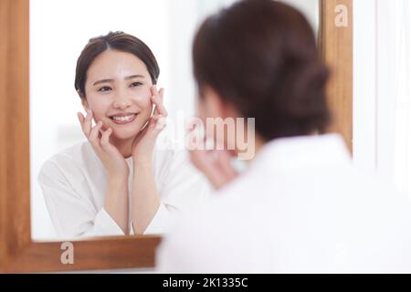 Japanische Frau macht Hautpflege zu Hause Stockfoto