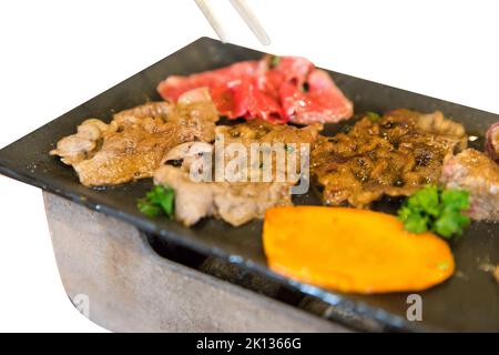 Stempelschnitt von gestreiftem Kalbsfleisch auf dem heißen panon weiß isoliert. Stockfoto