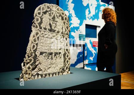 Mannheim, Deutschland. 15. September 2022. In der Sonderausstellung „die Normannen“ im Reiss-Engelhorn-Museum steht eine Frau hinter einem Bildstein von Smiss aus Gotland. Die Ausstellung 'die Normannen' beginnt am kommenden Sonntag (18.09.2022). Quelle: Uwe Anspach/dpa/Alamy Live News Stockfoto