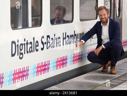 15. September 2022, Hamburg: Anjes Tjarks (Bündnis 90/die Grünen), Senatorin für Verkehr und Mobilitätswandel, verweist auf den Schriftzug "Digitale S-Bahn Hamburg" auf einer S-Bahn der Linie S2 am Bahnhof Bergedorf. Ab September 15 werden auf der Strecke S2 zwischen Berliner Tor und Bergedorf regelmäßig digital gesteuerte S-Bahnen verkehren. Foto: Marcus Brandt/dpa Stockfoto