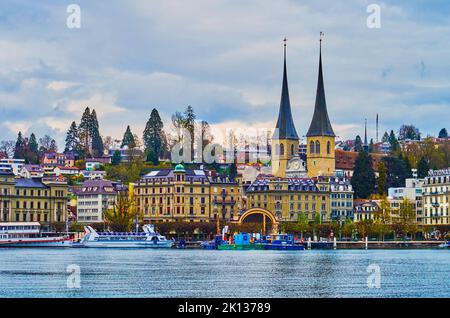 LUZERN, SCHWEIZ - 30. MÄRZ 2022: Die Türme der Kirche St. Leodegar und des Nationalquai-Damms, am 30. März in Luzern, Schweiz Stockfoto