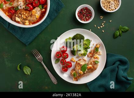 Hühnerschenkel mit Feta-Käse-Tomaten und Brokkoli, gesunde Keto-Mahlzeit Stockfoto