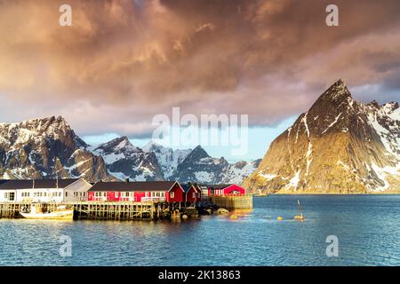 Gewitterwolken im Morgengrauen über Berggipfeln und Fischerdorf Sakrisoy, reine, Nordland County, Lofoten Islands, Norwegen, Europa Stockfoto