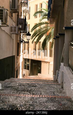 Benidorm, Alicante, Spanien - 9. September 2022: Schmale gepflasterte Straße mit Vintage-Straßenbeleuchtung in Benidorm Stockfoto