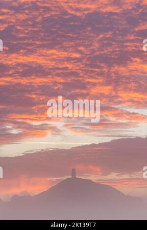 Spektakulärer Sonnenaufgang hinter dem Glastonbury Tor an einem nebligen Herbstmorgen, Somerset, England, Großbritannien, Europa Stockfoto