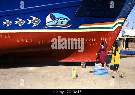 Die Familie des Bootsbesitzers führt Puja auf dem neuen Boot durch, indem sie Handabdrücke entlang seines Rumpfes vor dem Jungfernstart, Vanakbara, Gujarat, Indien, Asien, macht Stockfoto