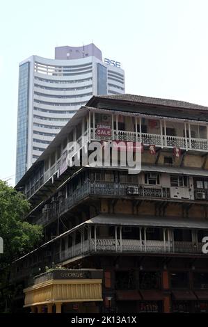 Der moderne BSE-Wolkenkratzer, früher die Bombay Stock Exchange, überschattet das heruntergekommene dreistöckige Gebäude aus der Raj-Ära, Mumbai, Indien und Asien Stockfoto