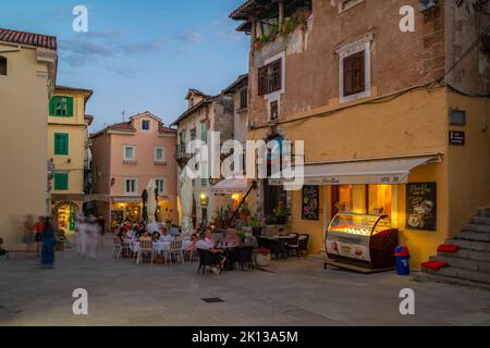 Blick auf Cafés. Restaurants und Geschäfte in der Abenddämmerung in Lovran Dorf, Lovran, Kvarner Bucht, Ostistrien, Kroatien, Europa Stockfoto
