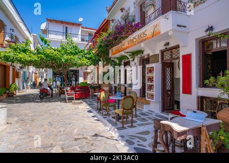 Blick auf Tavernen in der weiß getünchten Straße in Skiathos Stadt, Skiathos Insel, Sporaden Inseln, Griechische Inseln, Griechenland, Europa Stockfoto