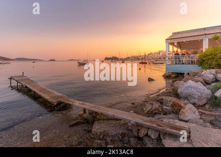 Blick auf Boote und Restaurants in Skiathos Stadt bei Sonnenuntergang, Skiathos Insel, Sporaden Inseln, griechische Inseln, Griechenland, Europa Stockfoto