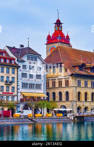 LUZERN, SCHWEIZ - 30. MÄRZ 2022: Der Uhrenturm und das alte Rathaus am Ufer des Reuss, am 30. März in Luzern, Schweiz Stockfoto